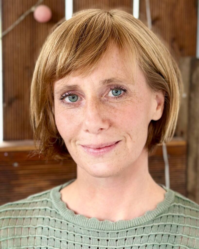 Annika Sukup, Virtuelle Assistentin – nahbares Porträt vor Holz-Hintergrund